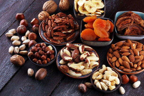 Trockenfrüchte und verschiedene Nüsse auf rustikalem Tisch. - Foto, Bild