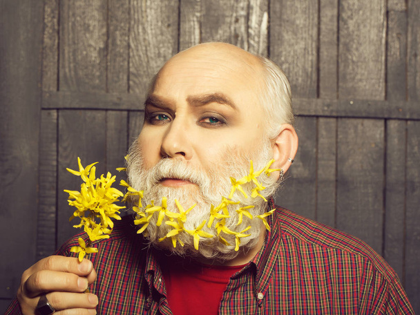 old man with flowers in beard - Фото, изображение