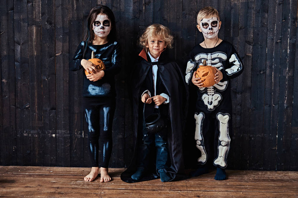 古い家でハロウィン パーティー中に怖い衣装で 3 人のかわいい子供. - 写真・画像
