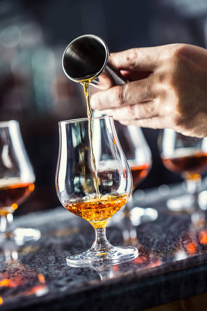 Bartender hand pouring alcoholic drink in nightclub, bar or pub. - Фото, зображення
