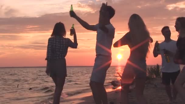 Des amis dansent sur la plage. Heure du coucher du soleil
. - Séquence, vidéo