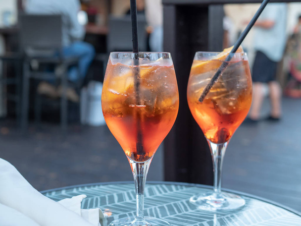 Two full spritz drinks sitting on outdoor table in restaurant - Foto, Bild