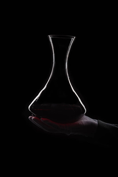 Wine decanting by man in white gloves at black background - Foto, imagen