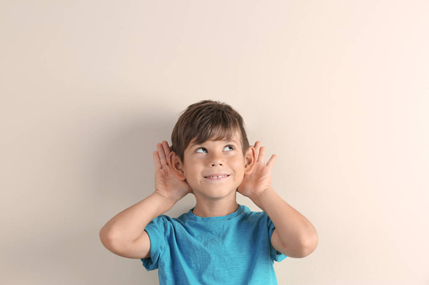 Cute little boy with hearing problem on light background - Фото, зображення