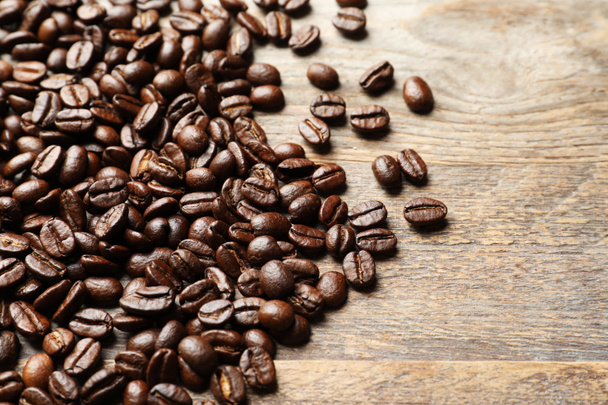 Pile of roasted coffee beans on wooden background - Foto, immagini