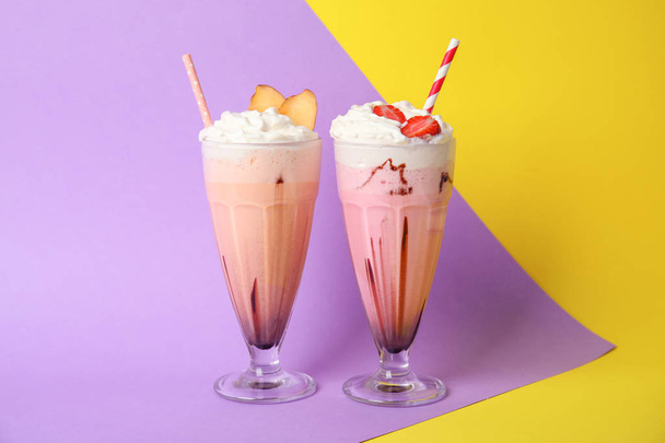 Glasses of tasty milk shakes on color background - Foto, afbeelding