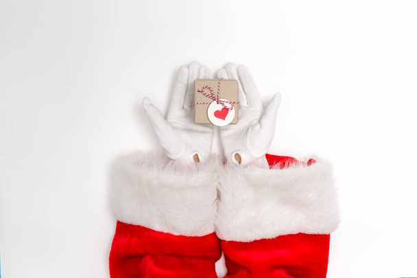 Santa holding a small Christmas gift - Photo, image