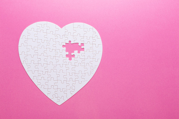 White puzzle heart on pink background. Top view - Foto, Imagem