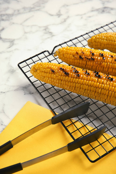 Cooling rack with grilled corn cobs on marble background - Foto, Imagen