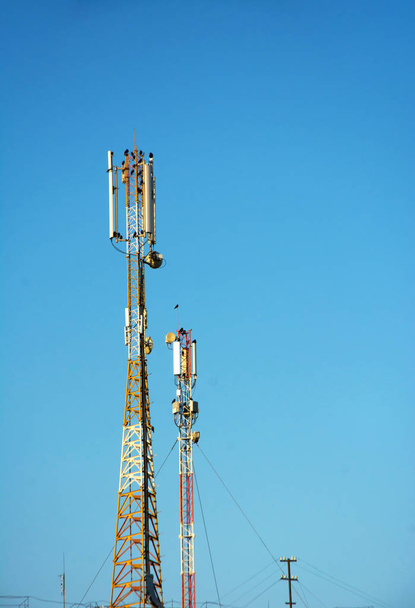 Большая башня с антеннами для связи сотовых телефонов. Участок сотовой связи 4G и 4.5G, радиовышка Телеком или базовая станция мобильной телефонной связи, рядом
 - Фото, изображение