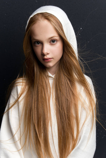 Portrait of beautiful young redhead girl posing in studio - Фото, изображение