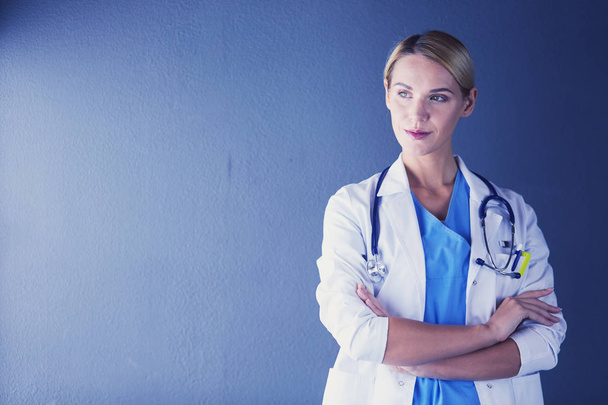 Portret młodej lekarki w białym płaszczu stojącej w szpitalu. - Zdjęcie, obraz