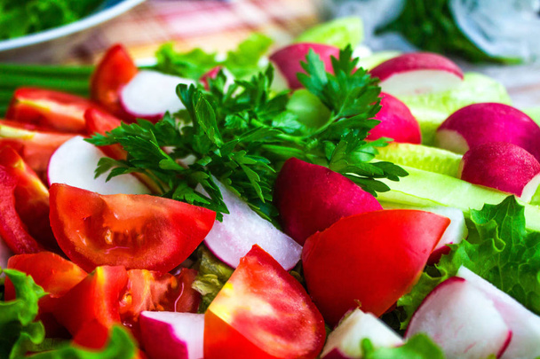 Fresh vegetables slicing: tomatoes, cucumbers, radish, salad and parsley, close up. - Photo, Image
