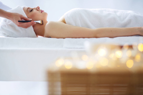 Young woman lying on a massage table,relaxing with eyes closed. Woman. Spa salon - Photo, Image