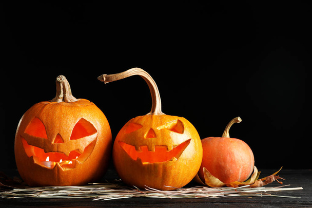 Halloween pumpkin head jack lanterns on table against dark background - Fotografie, Obrázek