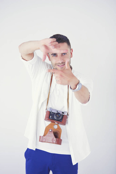 Young man with camera. Isolated over white background. - Foto, Bild