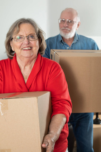 Senior Adult Couple Carrying Moving Boxes. - 写真・画像