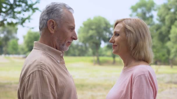 Senior man en vrouw hand in hand, kijken elkaar met liefde, gelukkige paar - Video