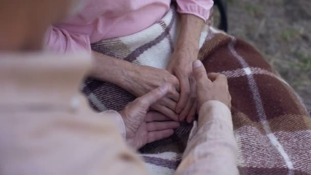 Man holding old female hands, family love and care, old couple in nursing home - Video