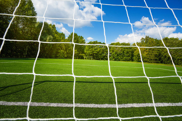 Football net and soccer stadium on background on clean empty playing field for kids - Photo, Image