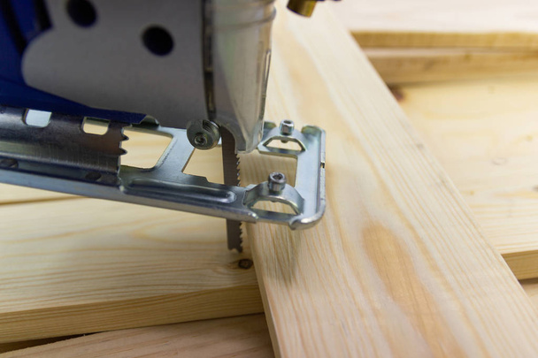 Close-up electric sawing jigsaw with wood the start process of cutting the board - Foto, afbeelding