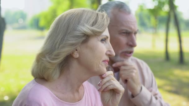Idős házaspár tárgyalja Hírek, beszél az élet, szabadtéri idősek otthona közelében ül - Felvétel, videó