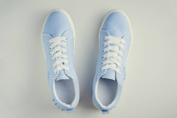 Zapatillas femeninas de rayas azules en una vista superior de fondo blanco. Piso poner fondo mínimo
 - Foto, Imagen