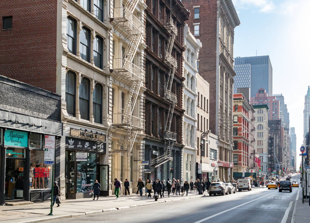 New York City, circa 2018: mensen lopen voorbij de winkels langs Broadway in de Soho-buurt van Manhattan in New York City. - Foto, afbeelding