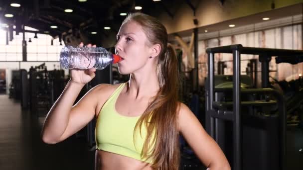 Conceito de vida saudável. Atlético mulher magro beber água após o treinamento em ginásio. Jovem e bela esportista sorrindo. 4k
 - Filmagem, Vídeo