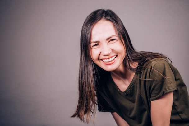 Human emotion. Beautiful brunette woman smiling and laughing at camera. Charming laugh - Фото, зображення