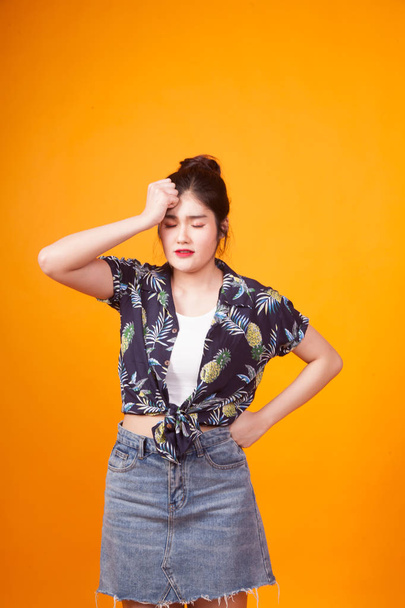 Young Asian woman got sick and  headache in  tropical shirt on yellow background - Fotoğraf, Görsel