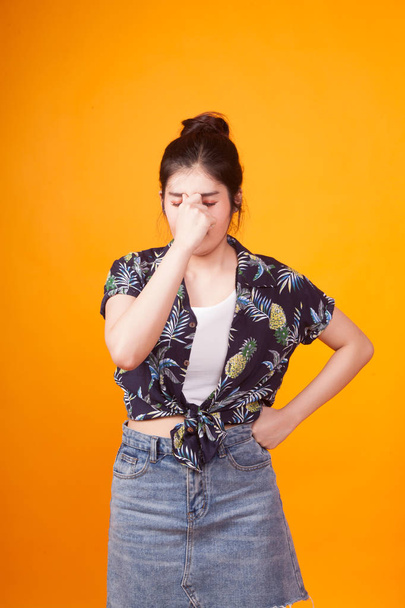 Young Asian woman got sick and  headache in  tropical shirt on yellow background - Photo, image