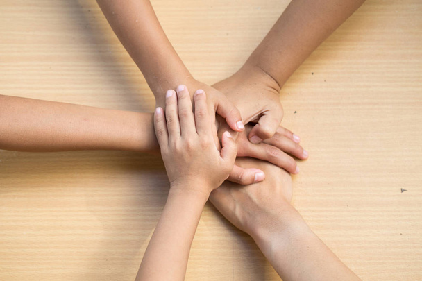 Nahaufnahme von oben, wie junge Menschen ihre Hände zusammenlegen. Freunde mit Handstapel zeigen Einigkeit und Teamwork. - Foto, Bild