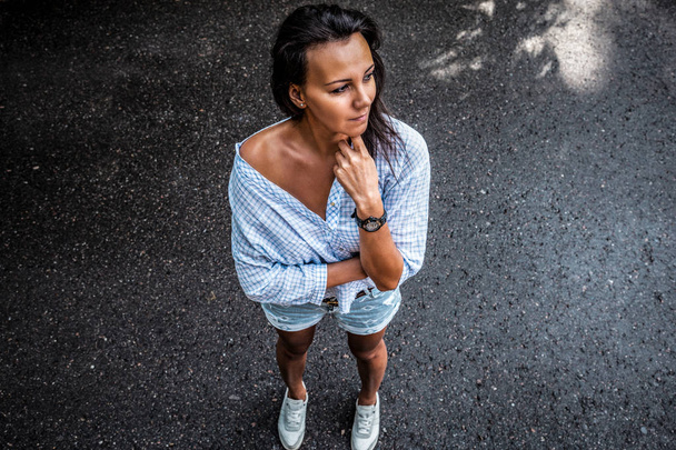 Contrast portrait of the top brunette. A middle-aged woman in a shirt and shorts. - Valokuva, kuva
