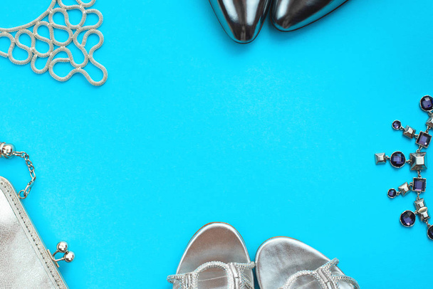 Zestaw akcesoriów mody lay płaskie buty torebka naszyjnik Biżuteria srebrna kolor na miejsce niebieskie tło widok z góry - Zdjęcie, obraz