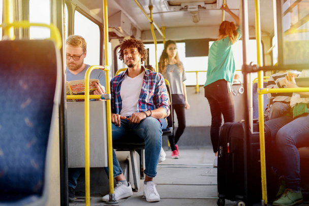 Obraz osoby siedzącej i stojącej w autobusie. - Zdjęcie, obraz