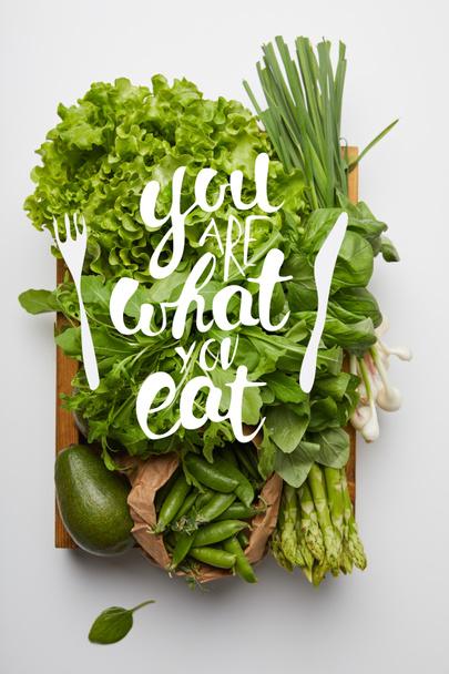 top view of various ripe vegetables in box on white surface with "you are what you eat" inspiration - Photo, Image
