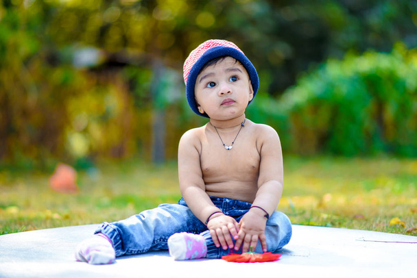 aranyos indiai kisfiú játszik a kertben - Fotó, kép