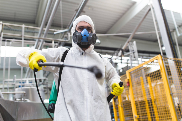 Szkodników kontroli pracownika ręka trzymając opryskiwacz dla rozpylania pestycydów w produkcji lub produkcji fabryki - Zdjęcie, obraz