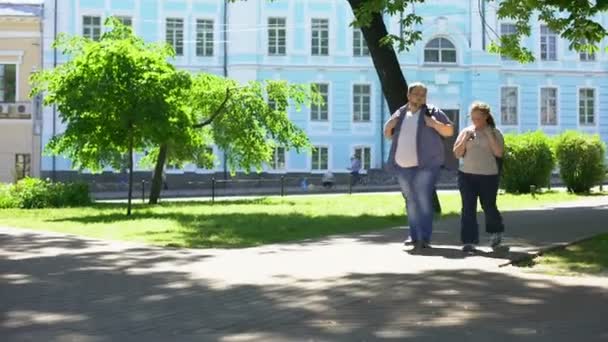Fat student couple walking in city park, urban date, leisure time, friendship - Materiaali, video