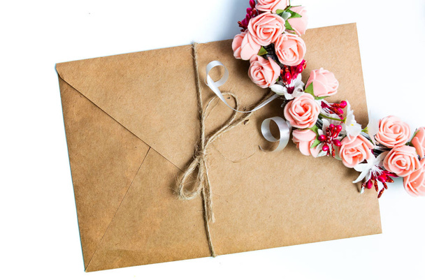 Briefumschlag und Blumenschmuck auf weiß isoliert - Foto, Bild