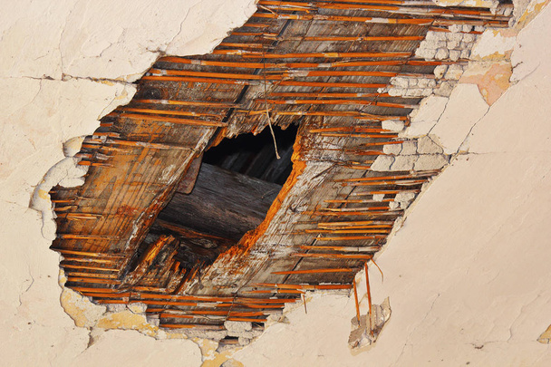 agujero en el techo después del ataque de hongos, descomposición en yeso y estructura de madera debido a infiltraciones de agua
 - Foto, Imagen