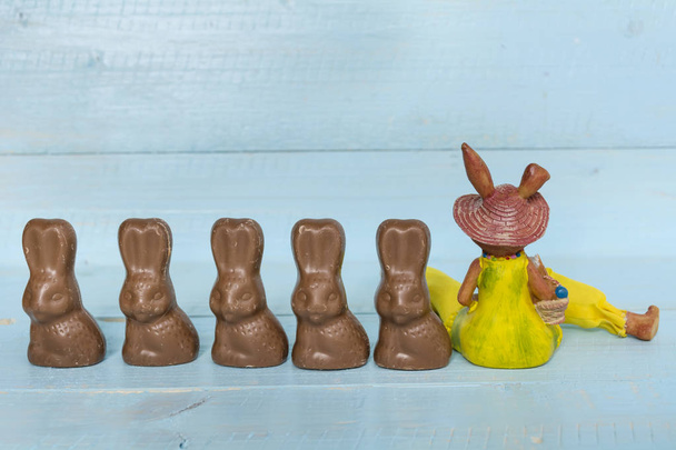 Chocolate Easter rabbits on a blue wooden background - Fotoğraf, Görsel