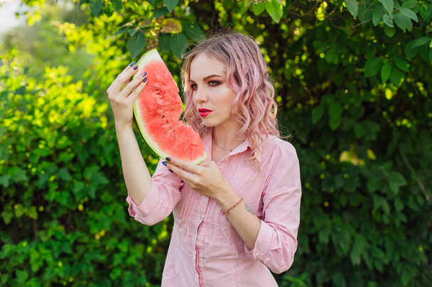 Beautiful young woman with pink hair enjoying sweet juicy watermelon - Φωτογραφία, εικόνα