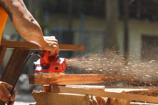 El carpintero trabaja con el pulidor eléctrico en la madera
. - Foto, Imagen