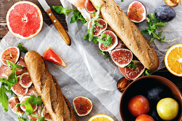 Sandwich with prosciutto, mascarpone cheese and figs on dark background top view copy space - 写真・画像