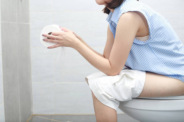 nő ül a WC-csészében fürdőlepedő. - Fotó, kép