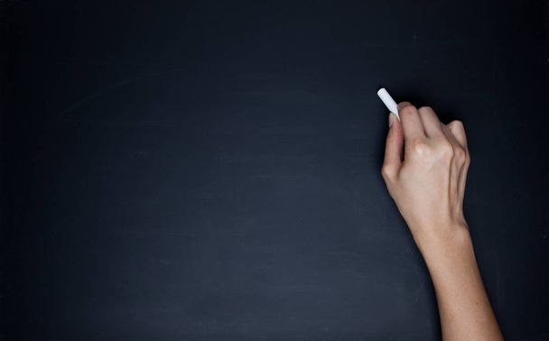 The human hand starts writing with chalk on a clean blackboard - Foto, Bild
