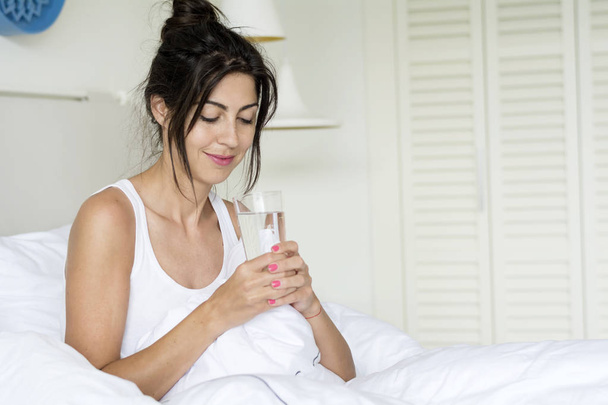 Beautiful Woman Drinking  Water in the Bed at the Morning.Healthy Start of the Day Concept - Valokuva, kuva