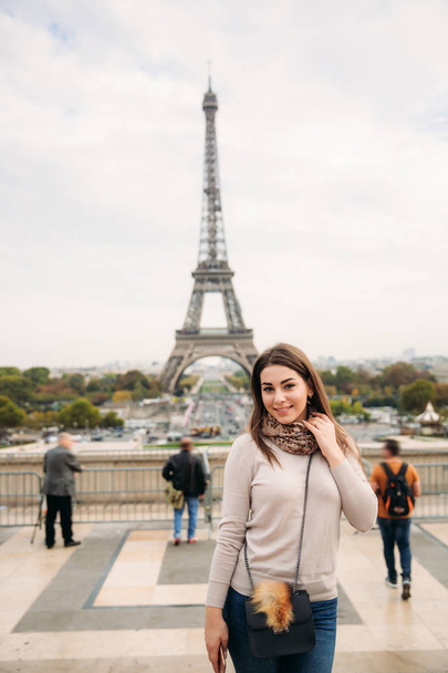 魅力的な若い女性は、パリの中心部に立っています。エッフェル塔の背景。旅行 - 写真・画像